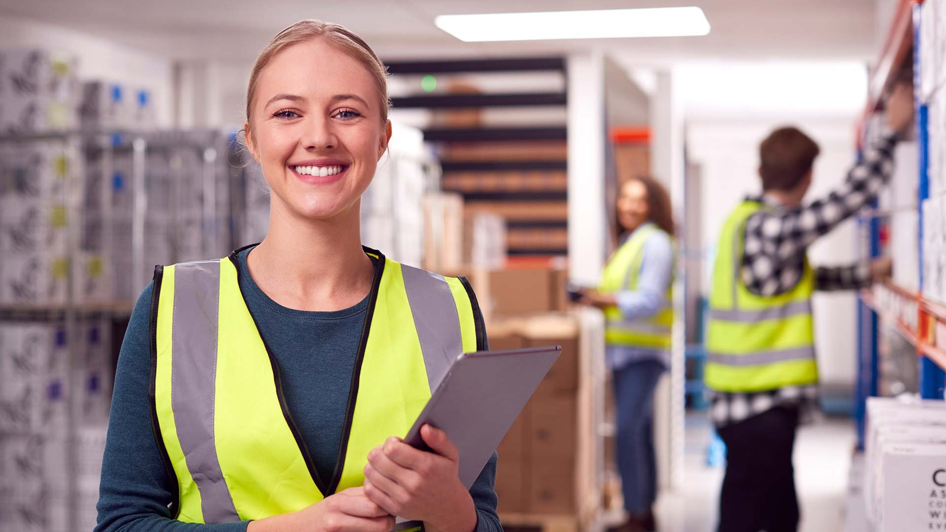 Eine Frau mit gelber Weste hat ein Tablet in der Hand Eine Frau mit gelber Weste hat ein Tablet in der Hand