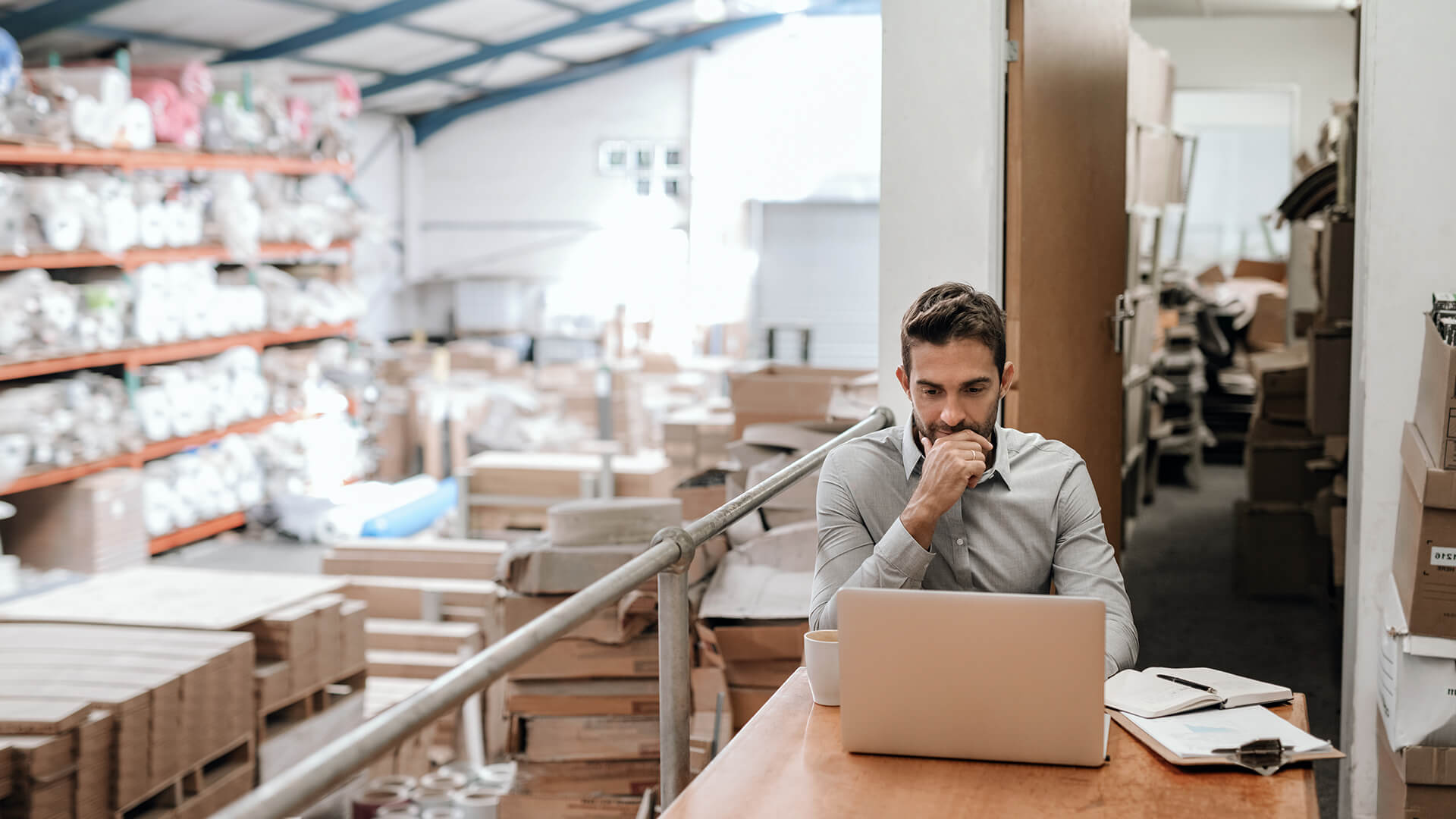 Lagermitarbeiter arbeitet am Laptop im Lager