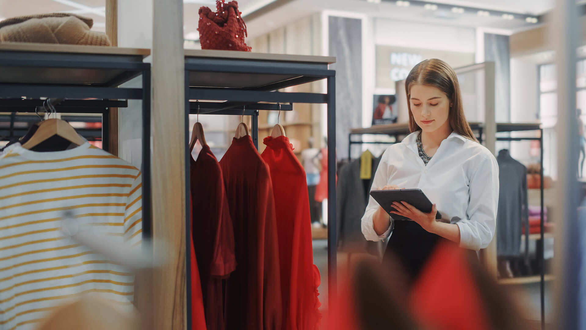 Vrouw met tablet in haar handen in het filiaal van een modewinkel